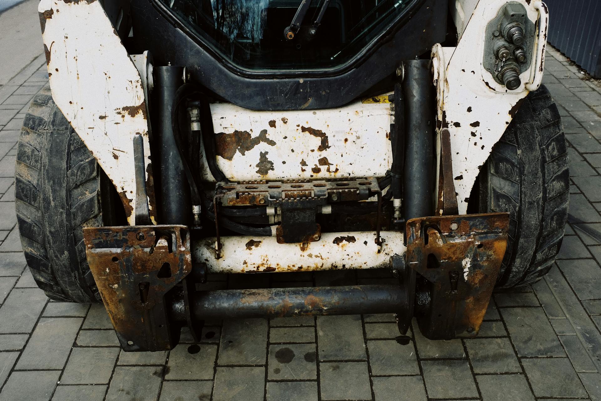 From above place of arm installation on shabby heavy duty mini loader with white frame