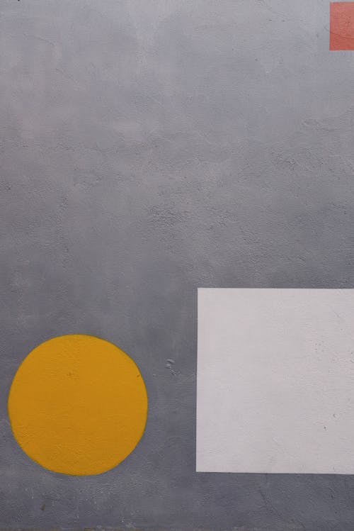 Yellow Circle and White Square on Gray Surface