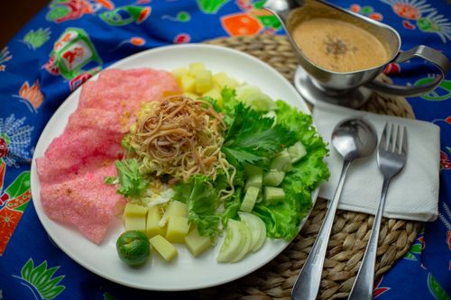 Free Colorful Indonesian gado-gado salad featuring fresh vegetables, pink crackers, and peanut sauce. Stock Photo