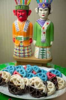 Vivid traditional sweets with colorful cultural figurines in the background. - Fotografer Sidoarjo
