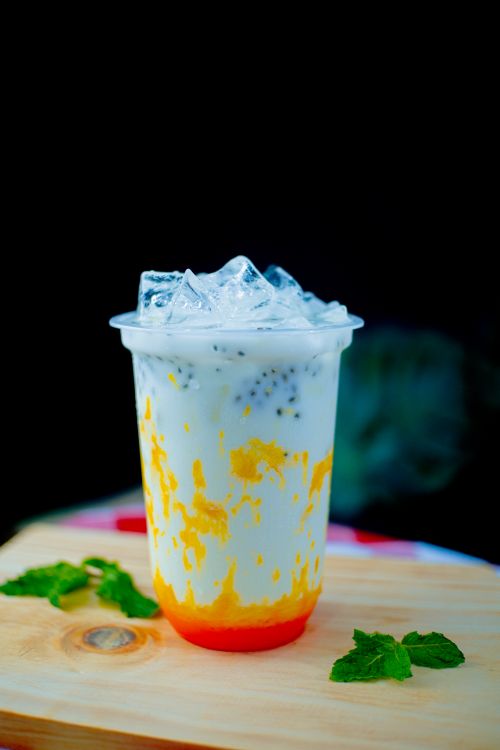 Free Chilled mango and chia seed drink with ice and mint on a wooden board. Stock Photo
