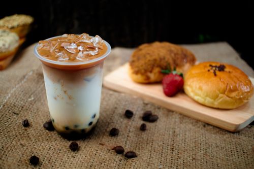 Free Iced coffee with pastries and strawberry on burlap table, perfect for breakfast or snack time. Stock Photo