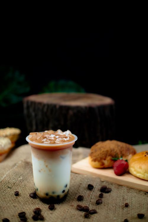 Free Iced bubble tea with pastries on rustic burlap, perfect for menus. Stock Photo