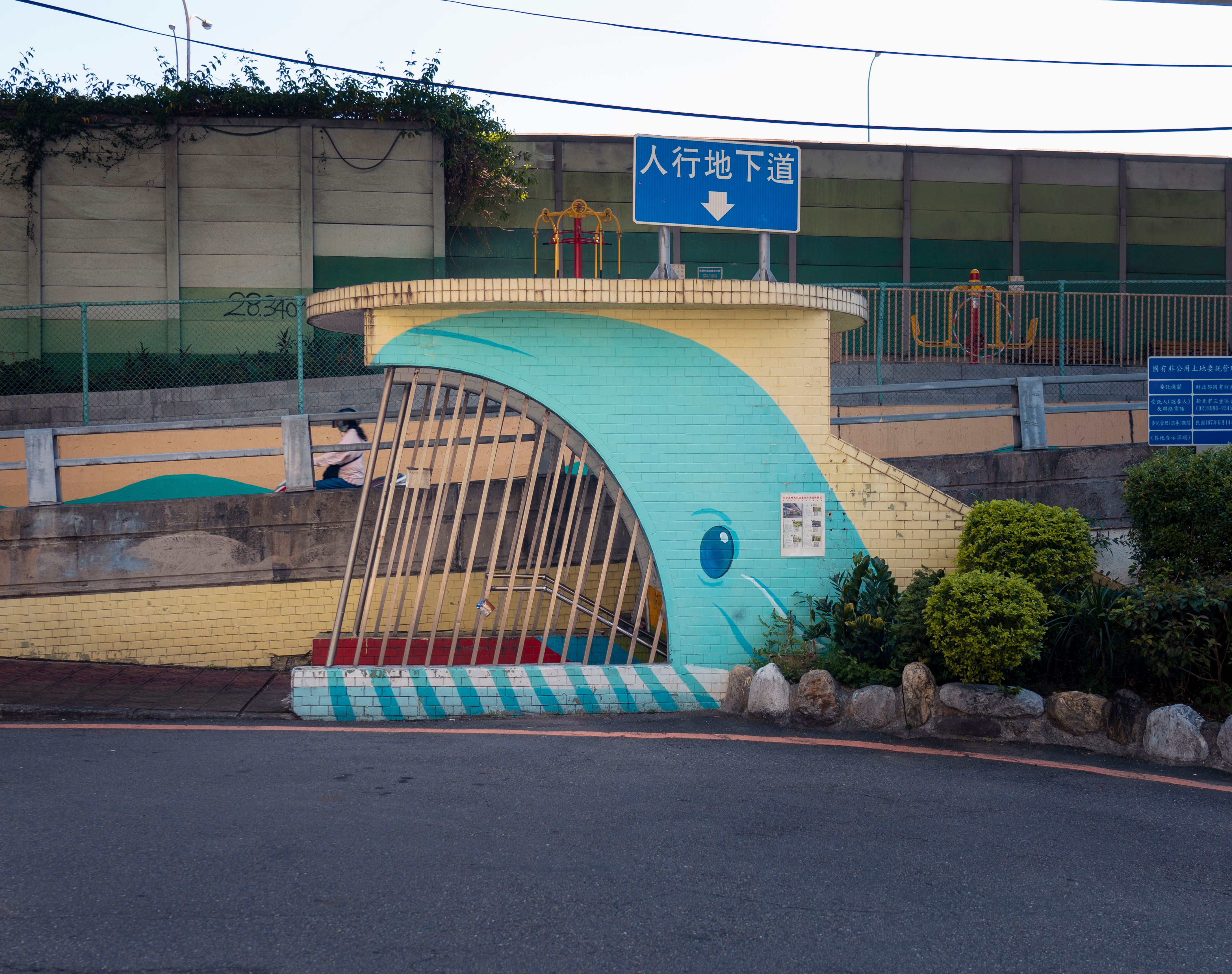 A vibrant whale-themed pedestrian underpass entrance in New Taipei City, Taiwan, showcasing artistic urban design.