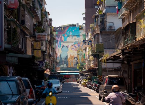 Free Vibrant street scene in Taipei with a large cat mural and urban alley view. Stock Photo