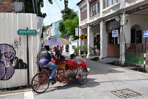 Free A vibrant street scene featuring a traditional rickshaw on Lebuh Muntri in Penang, Malaysia. Stock Photo