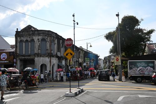 Free Bustling street scene in Penang with vintage architecture and a lively market setting. Stock Photo