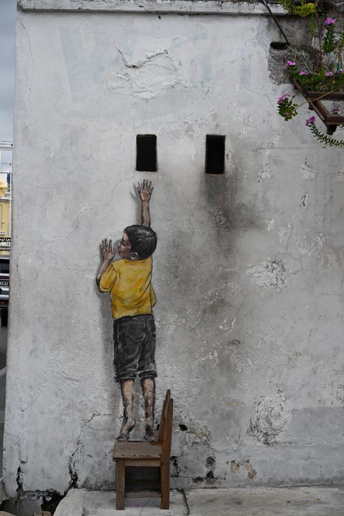 Free Street art depicting a child reaching up painted on a building wall. Stock Photo