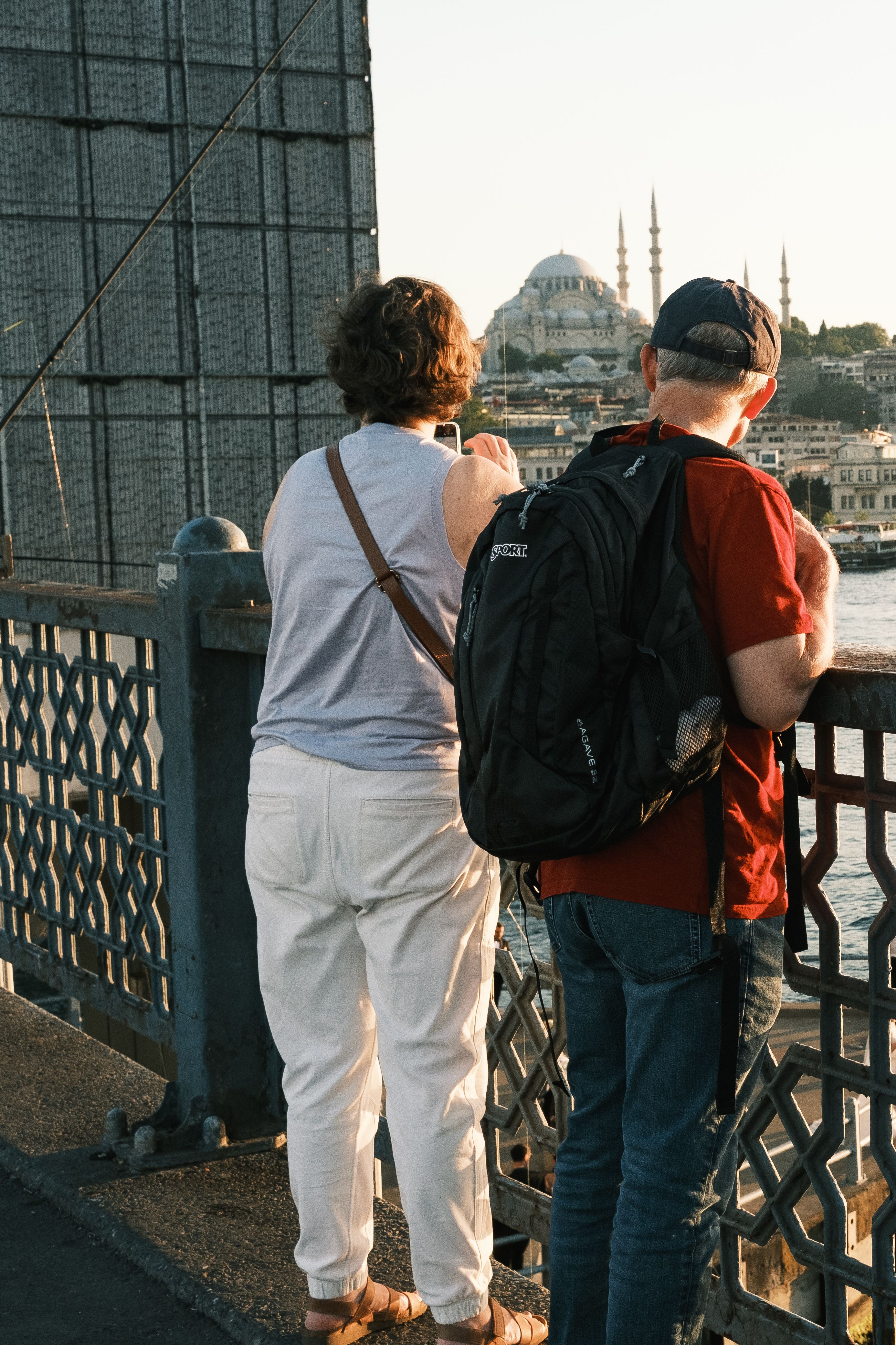 Tourists admire the Istanbul skyline from the Galata Bridge at sunset.