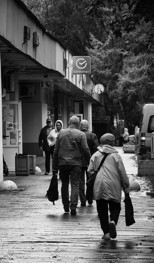 Free Black and white photo of people walking on a rainy street, capturing an urban moment. Stock Photo