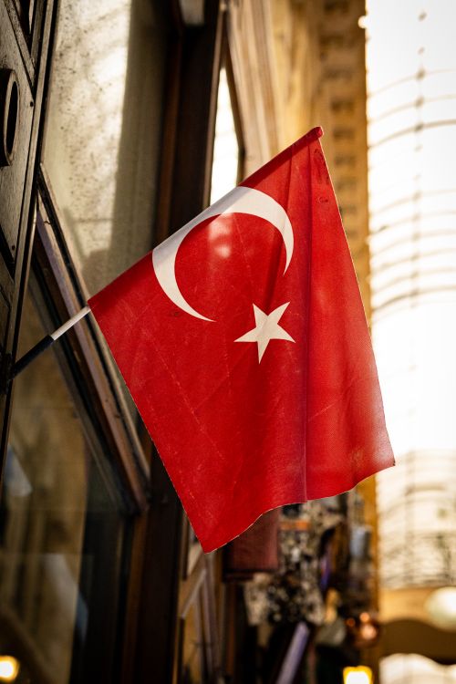 Free Turkish flag in a historic passage in Istanbul, capturing cultural essence. Stock Photo