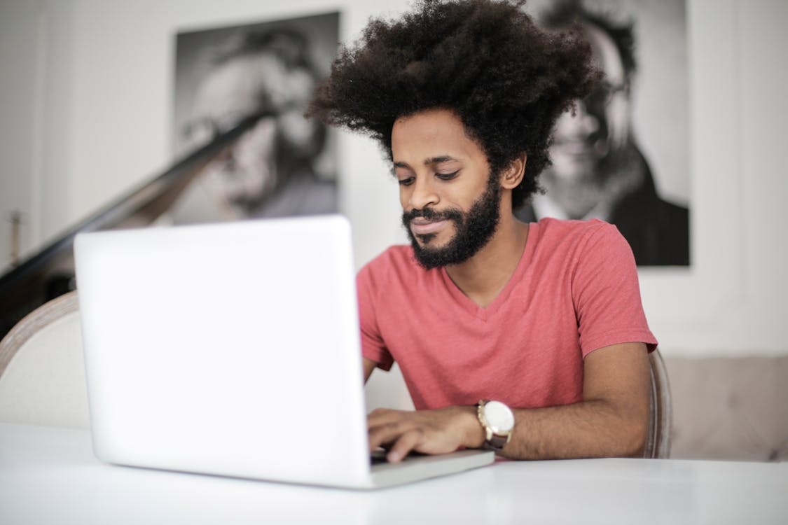 Man in Red Crew Neck T-shirt Using Laptop