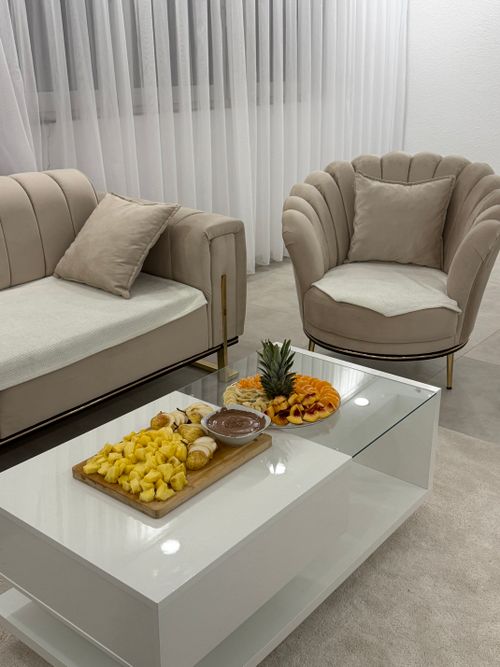 Free Elegant modern living room interior with plush seating and a tropical fruit platter enhancing the cozy ambiance. Stock Photo