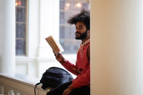 Man Reading a Book while Waiting For His Next Class