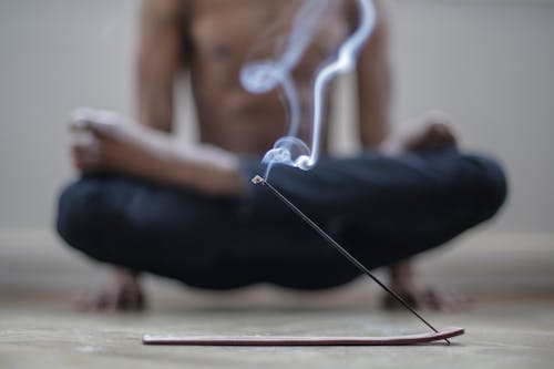 Free Man Using Incense while Doing Yoga Stock Photo
