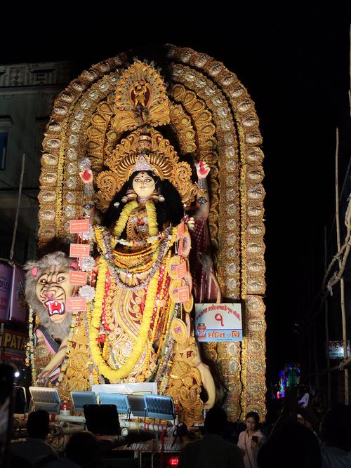 Free Vibrant Durga Puja festival scene with lit statue at night, attracting crowds. Stock Photo