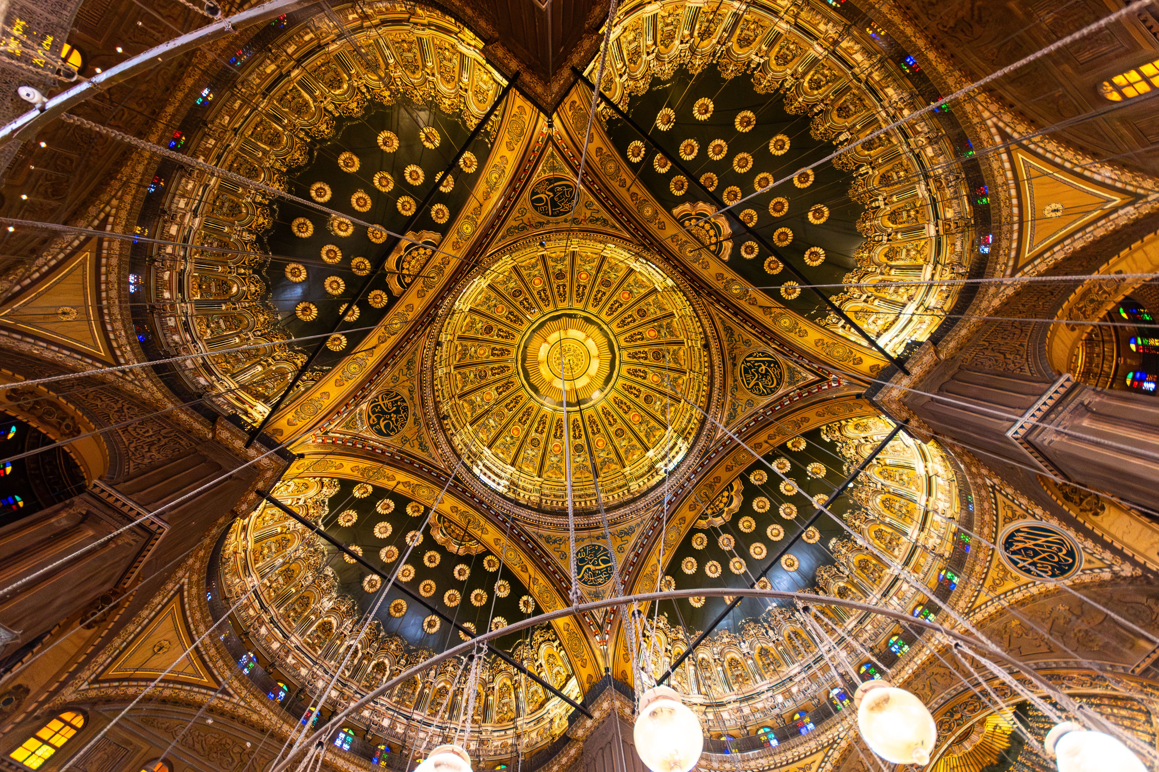 Intricate details of a golden mosque dome featuring elaborate patterns.