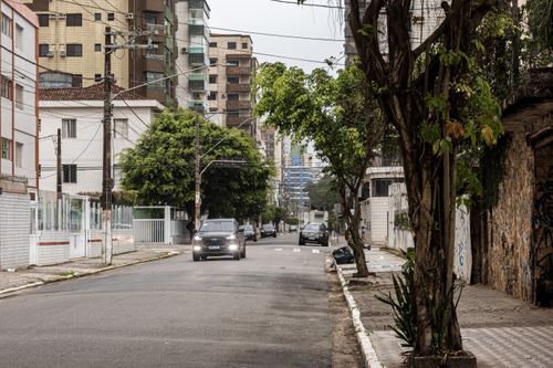 Free A quiet street in Praia Grande with cars, trees, and urban buildings. Stock Photo