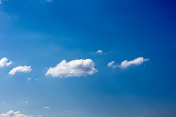 Um céu azul vibrante com nuvens cúmulos fofas em uma atmosfera serena.