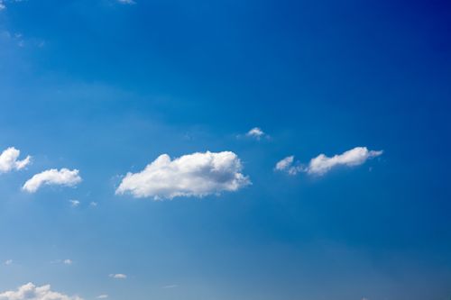 Free A vibrant blue sky featuring fluffy cumulus clouds in a serene atmosphere. Stock Photo