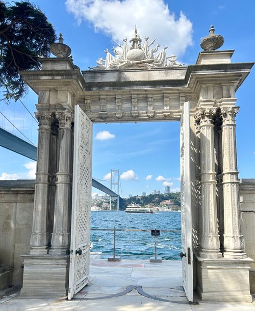 Free A beautiful ornate gate at Dolmabahçe Palace frames a view of the Bosporus Bridge in Istanbul. Stock Photo