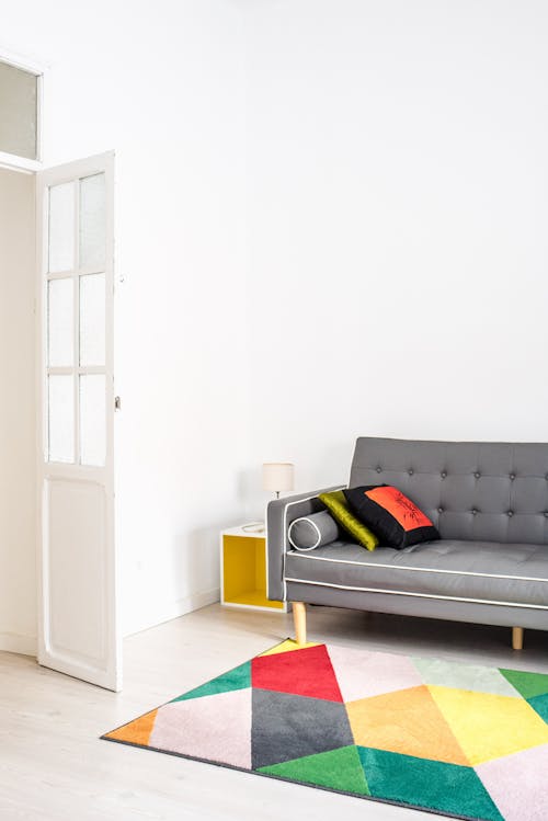 Gray Couch with White Accent Beside White Wall