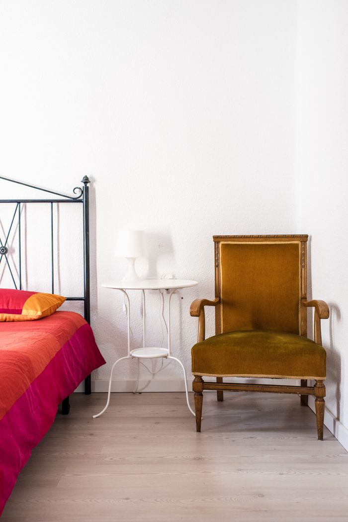 Habitación luminosa con cama, sillón y luz natural