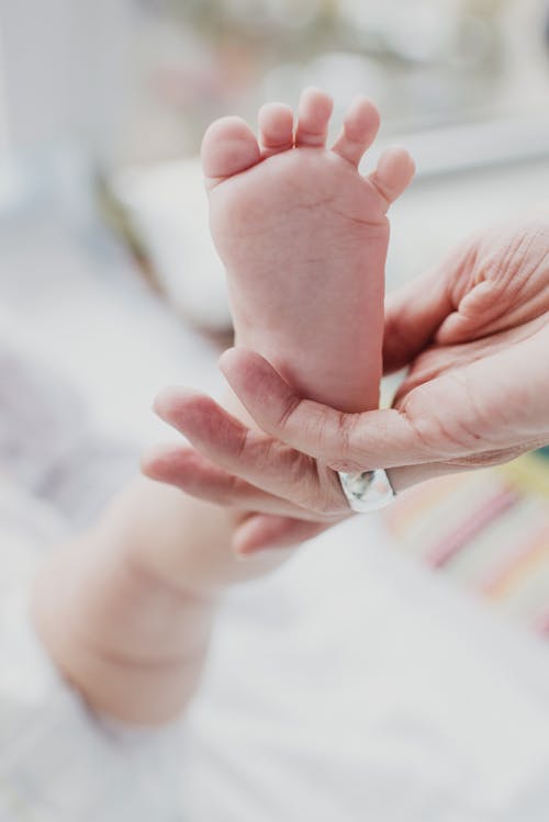 Person Holding Baby's Foot