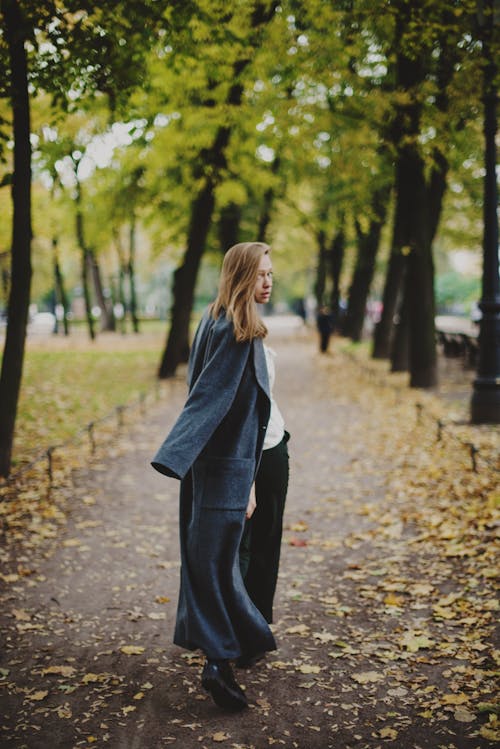 Free Woman in Black Coat Standing on Brown Leaves Stock Photo