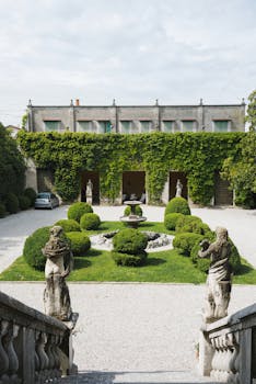 迷人的室外庭院中设有雕塑、郁郁葱葱的绿植和一座经典喷泉