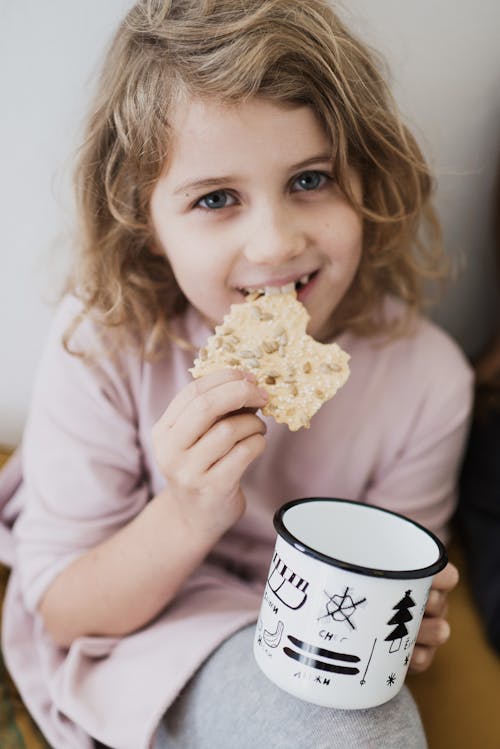 Free Girl Eating Biscuit and Milk Stock Photo