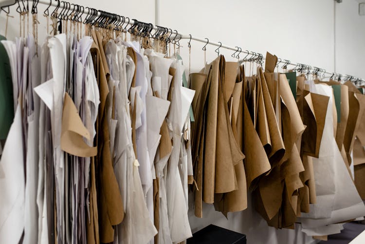 Assorted Sewing Patterns On Hangers Inside Tailor Atelier