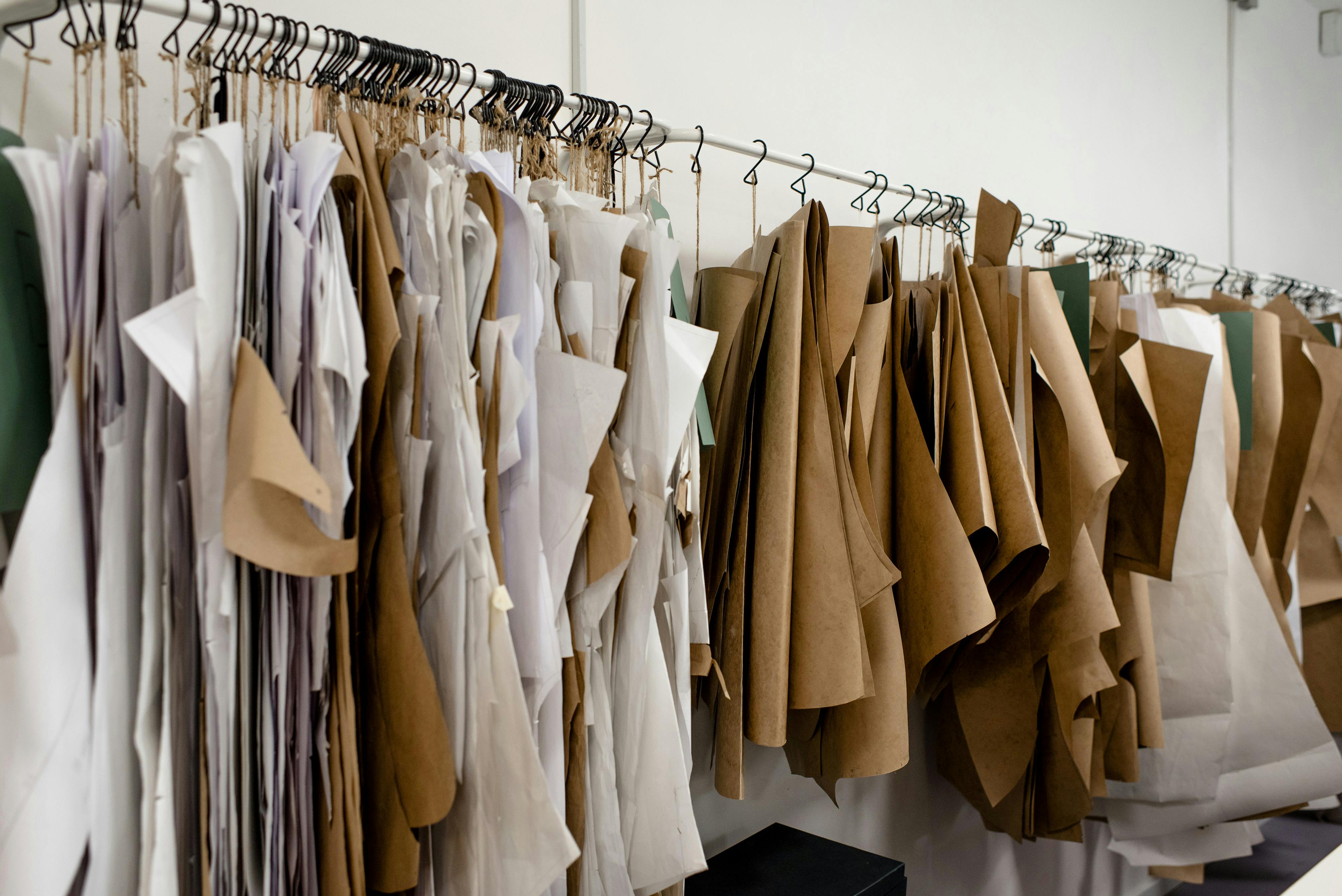 Assorted sewing patterns on hangers inside tailor atelier \u00b7 Free Stock Photo
