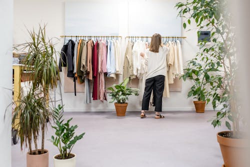 Woman Fixing Clothes on the Rack