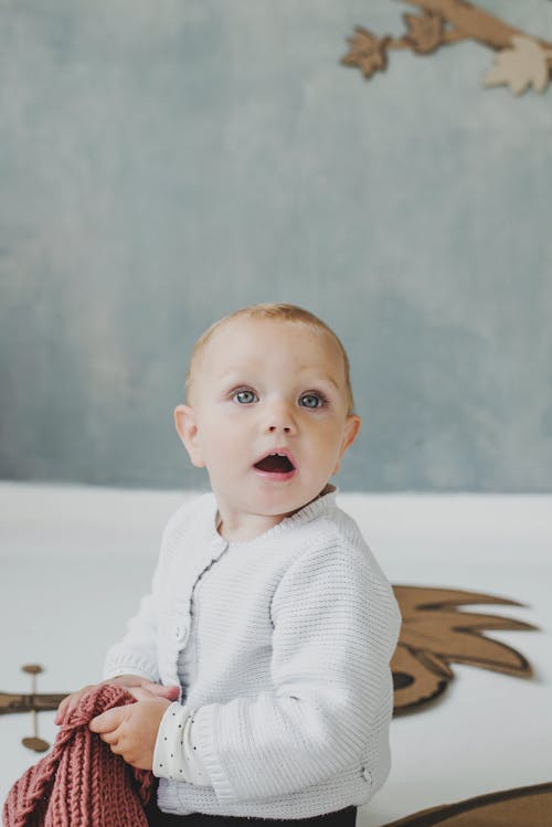 Free Baby in White Sweater Sitting on the Floor Stock Photo