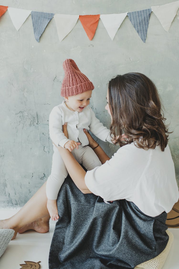 Woman In White Blouse Holding A Child