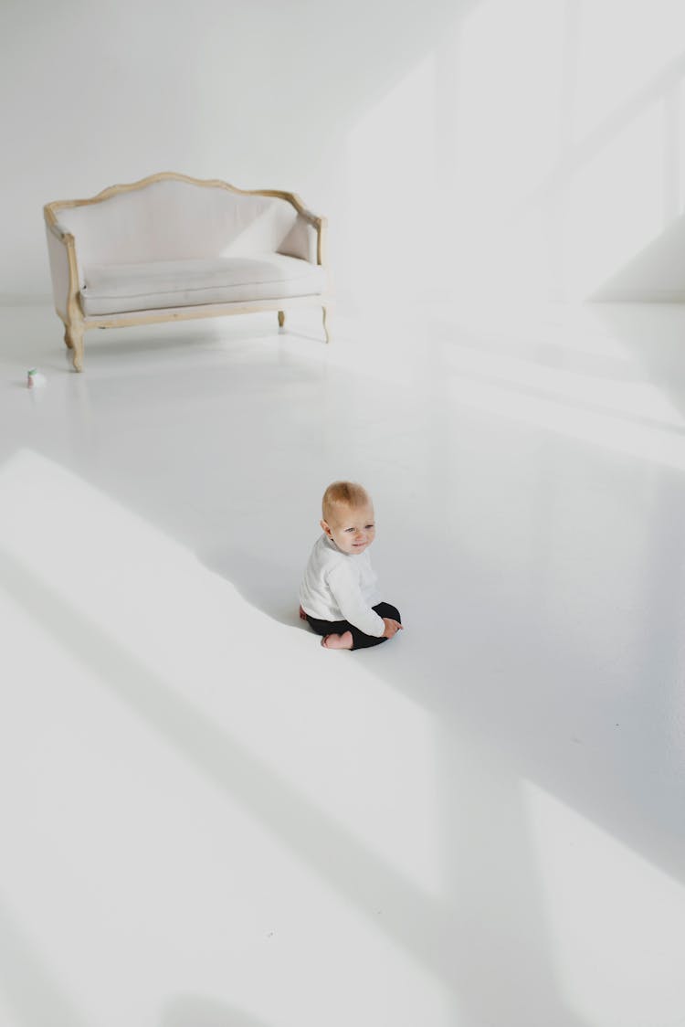 Baby Sitting On White Flooring