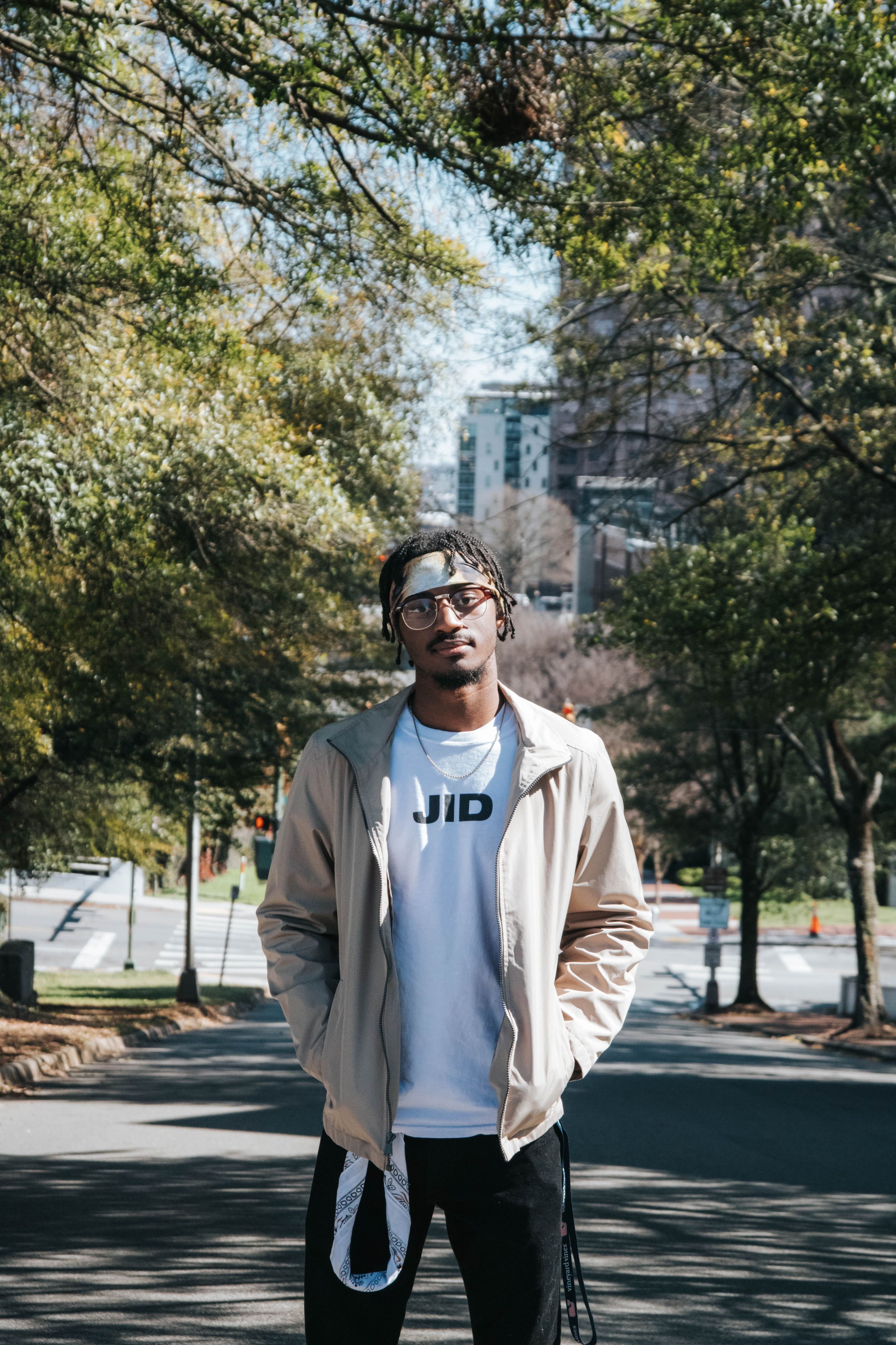 Stylish young adult in urban park setting, showcasing modern lifestyle and fashion.