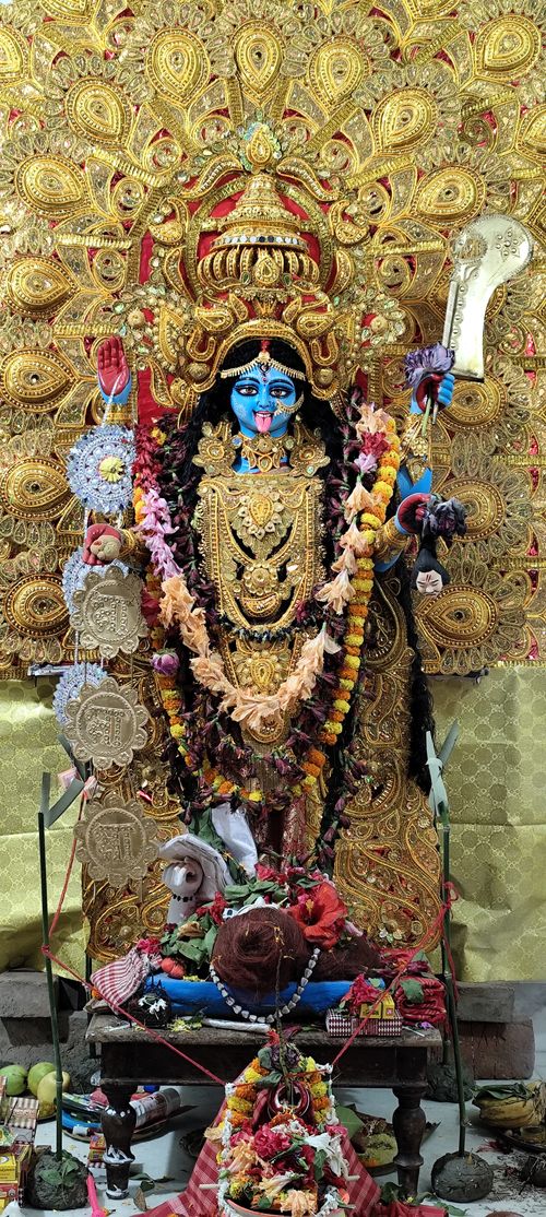 Free Detailed image of a traditional Kali idol adorned with flowers and gold embellishments. Stock Photo
