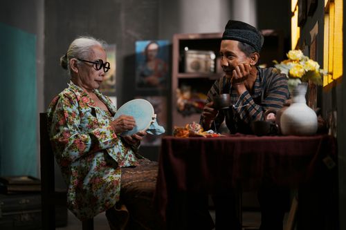 Free An elderly couple shares a moment of crafting in a cozy Indonesian home. Stock Photo