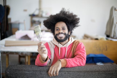 Man in Pink Hoodie Holding a Paintbrush