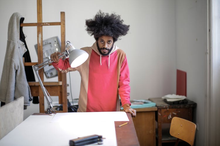 Man Fixing The Lamp On His Table