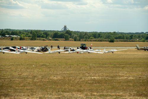 Free A serene outdoor scene with gliders lined up on an airfield under a clear sky. Stock Photo
