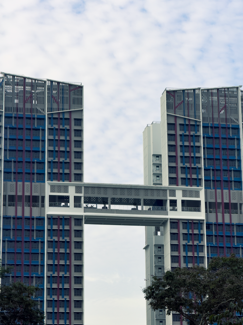 Free Skybridge connects modern high-rise buildings under a cloudy sky. Stock Photo