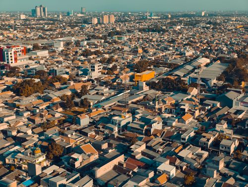 Free Stunning aerial view of Surabaya, showcasing the dense urban landscape under the sunny daytime sky. Stock Photo
