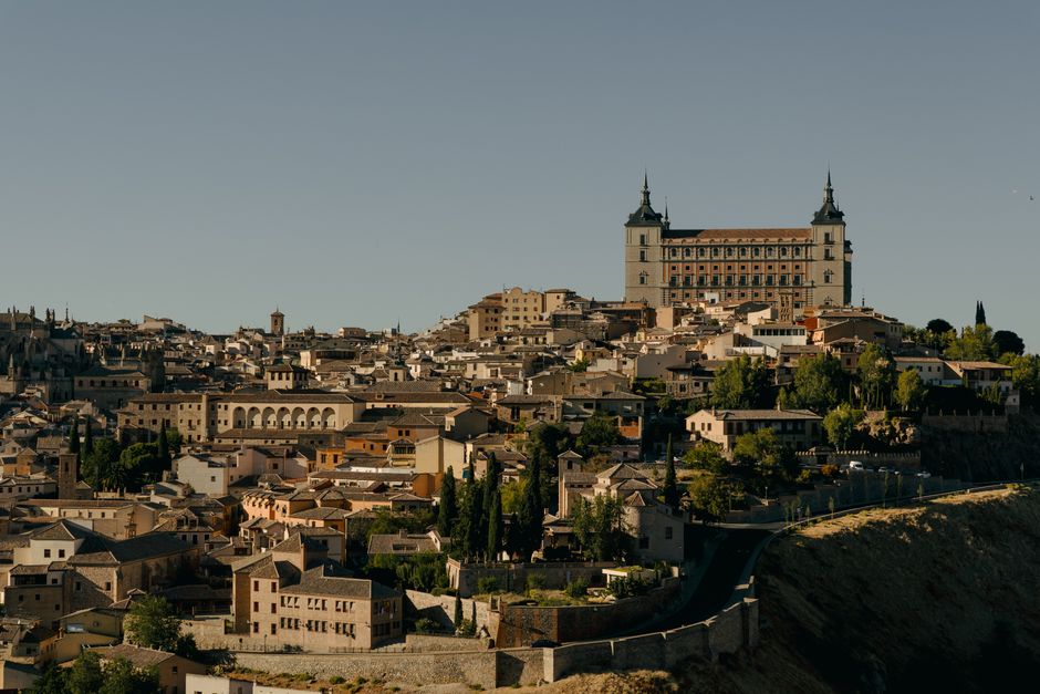 A stunning view of Toledo, Spain showcasing its historic architecture and the iconic Alcázar under clear skies.