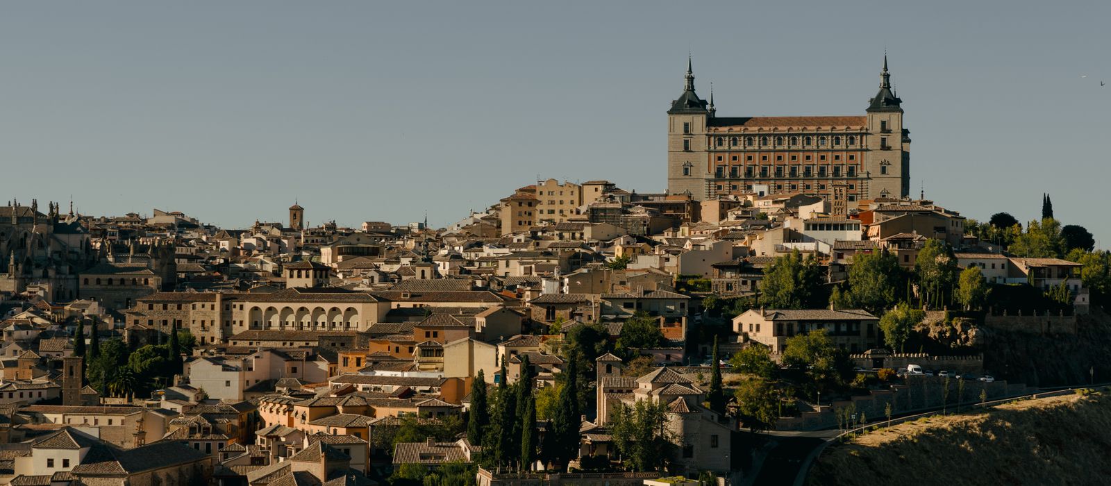 A stunning view of Toledo, Spain showcasing its historic architecture and the iconic Alcázar under clear skies.