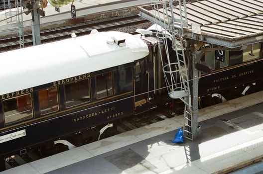 Vintage European train on a station platform, showcasing elegant railway travel.