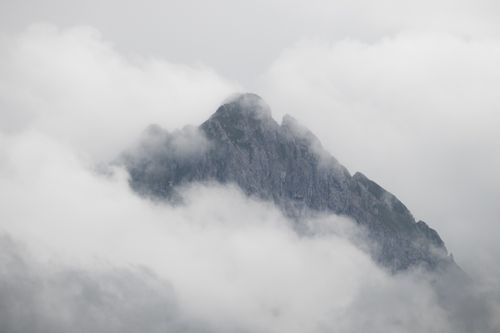 Free A striking image of a Swiss mountain peak shrouded in mist, evoking a serene and mysterious atmosphere. Stock Photo