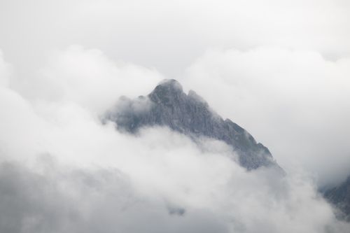 Free A dramatic view of a mountain peak in the Swiss Alps partially obscured by clouds, capturing nature's grandeur. Stock Photo